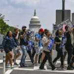 Demonstrators in favor of cancelling student debt march from the Supreme Court to the White House in Washington, June 30, 2023. (Kenny Holston/The New York Times)