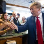 Former President Donald Trump greets people behind the counter at a restaurant in Miami during a campaign stop on June 13, 2023.  (Doug Mills/The New York Times)