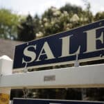 A 'sale' sign advertises a home
