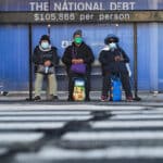 three people under national debt sign